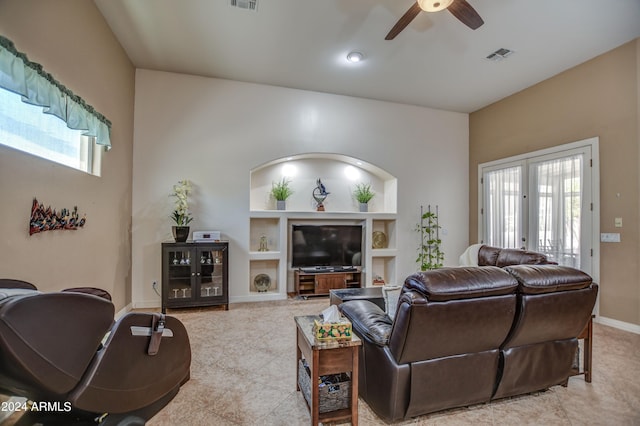 living area with built in features, visible vents, ceiling fan, and french doors