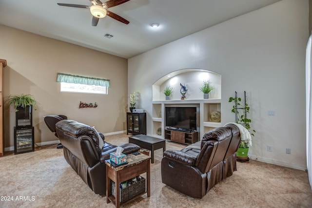 living room featuring visible vents, built in shelves, baseboards, and a ceiling fan