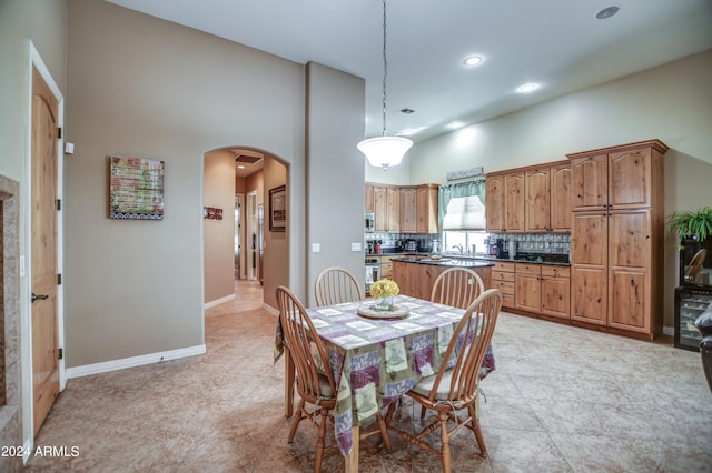 dining room featuring visible vents, recessed lighting, arched walkways, baseboards, and a towering ceiling