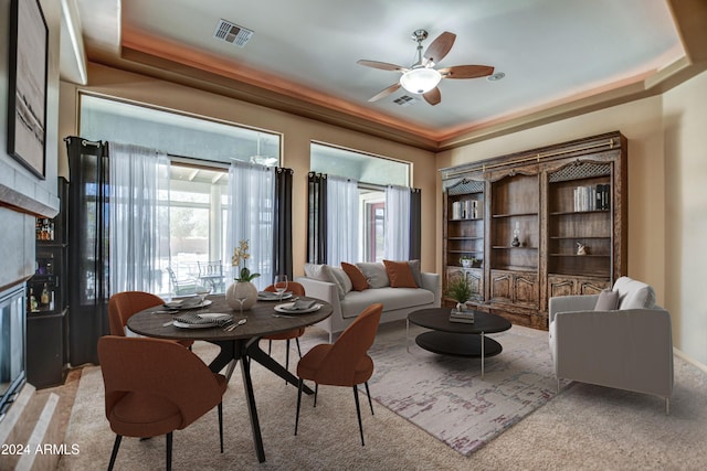 living area featuring visible vents, a raised ceiling, and light carpet