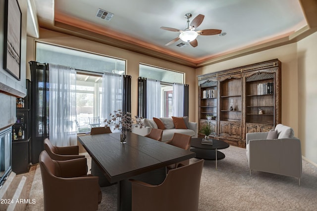 dining area featuring ceiling fan, a tray ceiling, visible vents, and light carpet