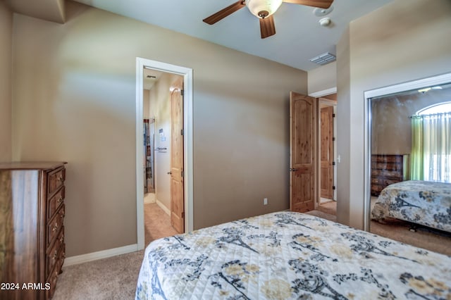 bedroom with visible vents, a closet, baseboards, light colored carpet, and ceiling fan