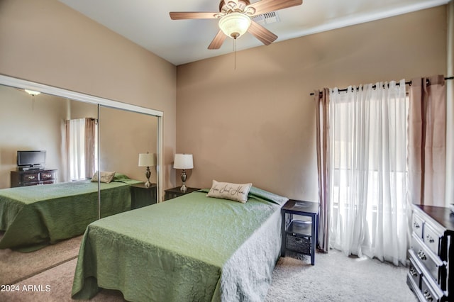 carpeted bedroom with multiple windows, visible vents, a closet, and ceiling fan