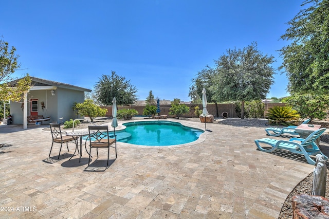 view of swimming pool with a patio, a fenced backyard, a fenced in pool, and an outdoor structure