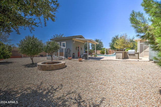 back of property featuring a patio, a fenced backyard, a fenced in pool, and a fire pit