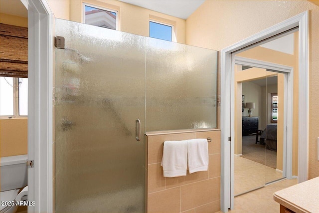 bathroom featuring toilet, vanity, and an enclosed shower