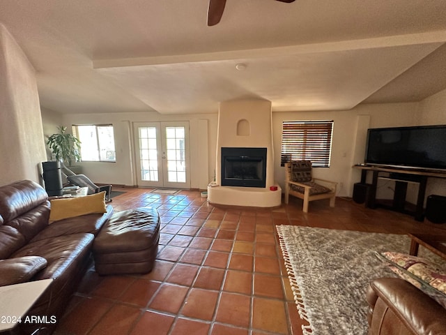 living room featuring french doors, ceiling fan, tile patterned floors, and a large fireplace