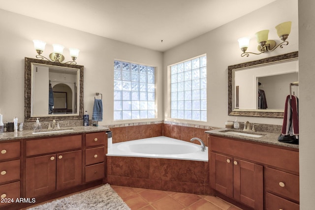 bathroom featuring vanity, tile patterned flooring, and tiled tub