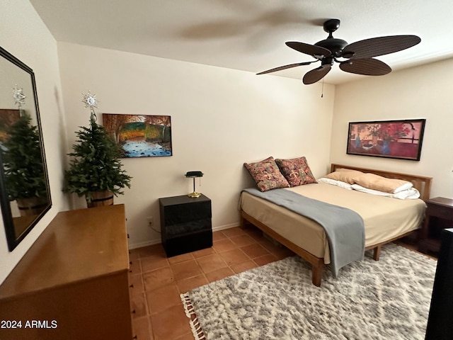 tiled bedroom featuring ceiling fan