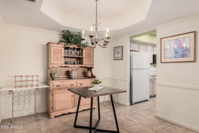 dining area featuring crown molding, light tile patterned flooring, a raised ceiling, and a chandelier