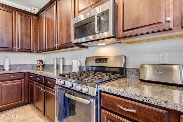 kitchen with stainless steel appliances and light stone counters