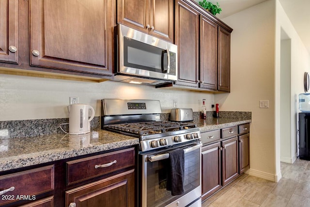 kitchen with stainless steel appliances and dark stone counters