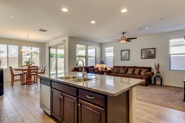 kitchen with pendant lighting, sink, dark brown cabinetry, a center island with sink, and stainless steel dishwasher