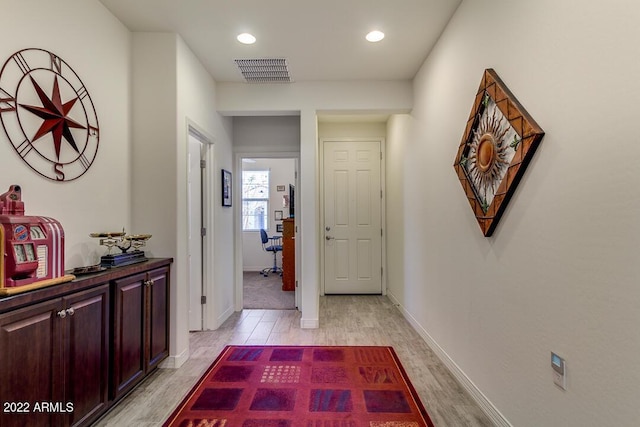 hallway with light hardwood / wood-style floors