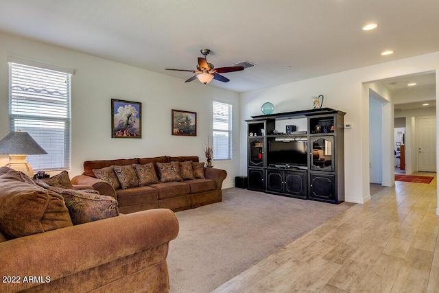 carpeted living room with ceiling fan