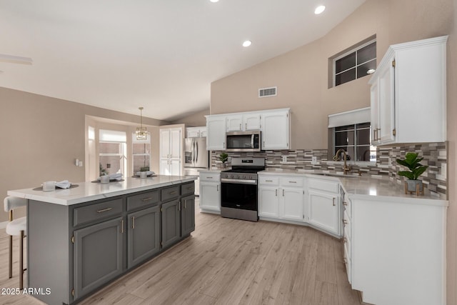 kitchen featuring light countertops, appliances with stainless steel finishes, white cabinetry, and gray cabinetry