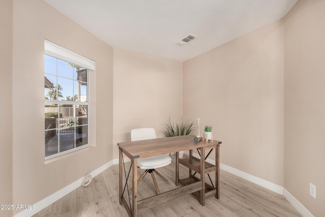 office space featuring light wood-style flooring, visible vents, and baseboards