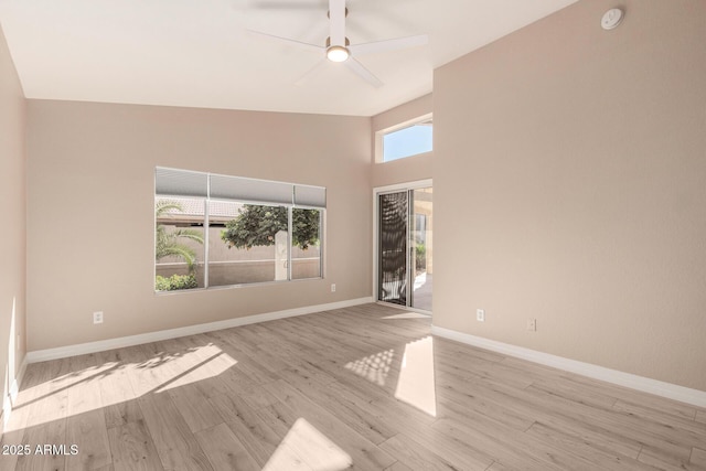 unfurnished room with high vaulted ceiling, a ceiling fan, light wood-style flooring, and baseboards