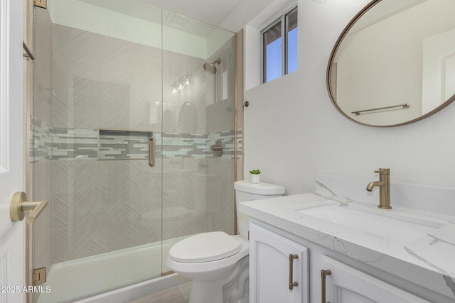 bathroom featuring toilet, tiled shower, and vanity