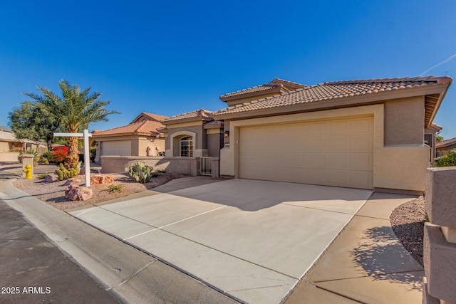 mediterranean / spanish-style home with a garage, fence, driveway, a tiled roof, and stucco siding