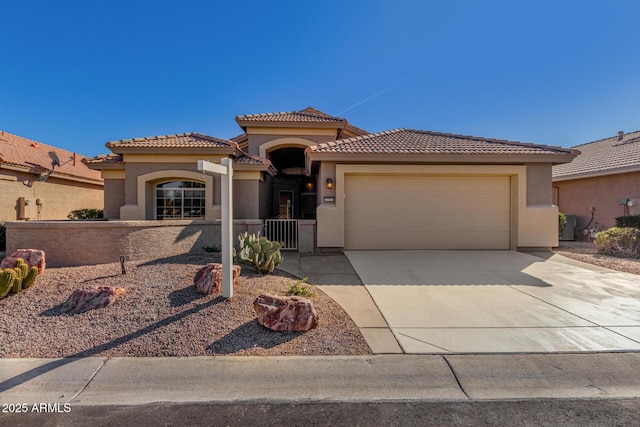 mediterranean / spanish home featuring driveway, a tile roof, a garage, and stucco siding