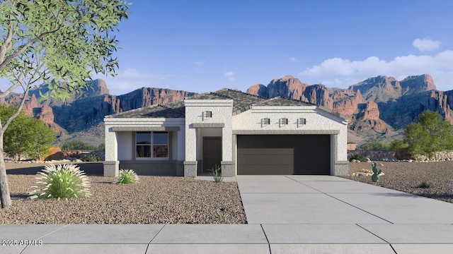 view of front of house featuring a garage, driveway, a mountain view, and stucco siding