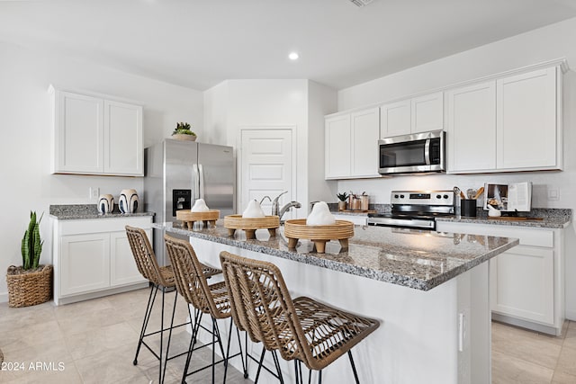 28242 N Nealite Dr, San Tan Valley, AZ 85143 - kitchen featuring appliances with stainless steel finishes, stone countertops, a kitchen breakfast bar, recessed lighting, and white cabinetry