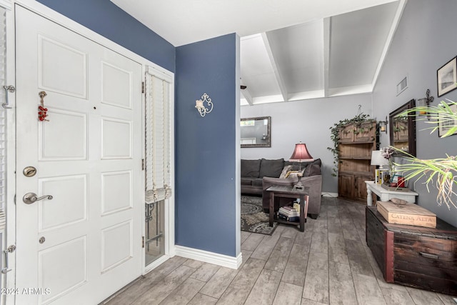 foyer with light hardwood / wood-style flooring and lofted ceiling