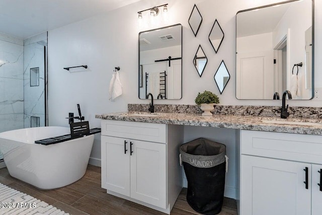 bathroom with hardwood / wood-style floors, vanity, and independent shower and bath