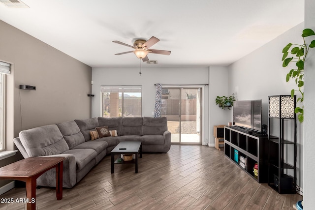 living area with wood finished floors, a ceiling fan, and visible vents