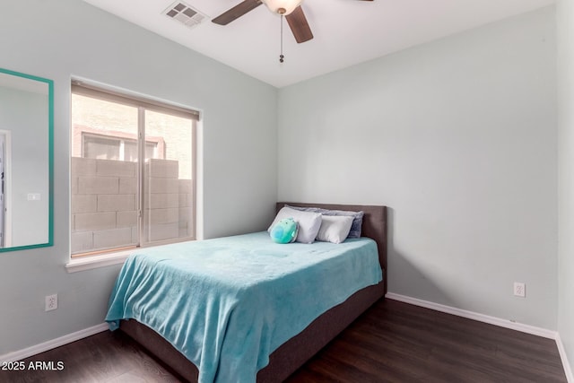 bedroom with visible vents, baseboards, and wood finished floors