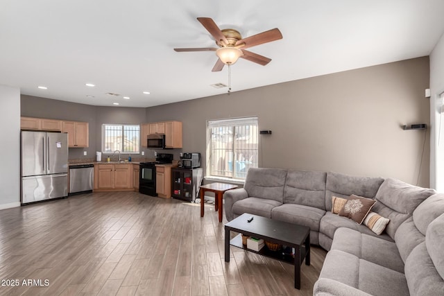 living room featuring recessed lighting, a healthy amount of sunlight, light wood finished floors, and ceiling fan