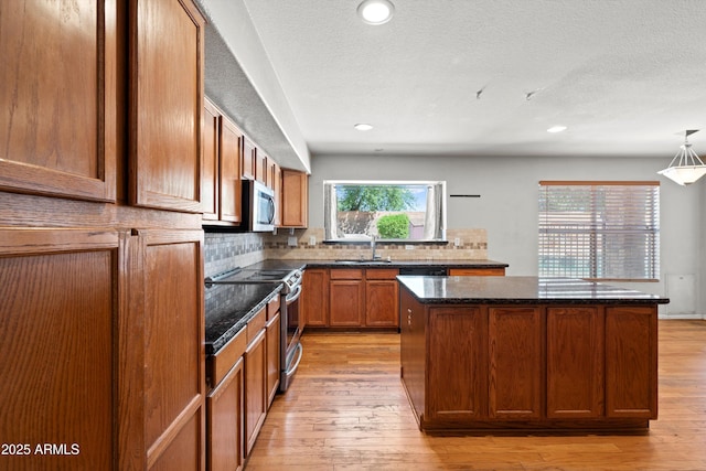 2024 N 125th Ave, Avondale, AZ 85392 - kitchen with appliances with stainless steel finishes, a kitchen island, decorative backsplash, light wood finished floors, and recessed lighting