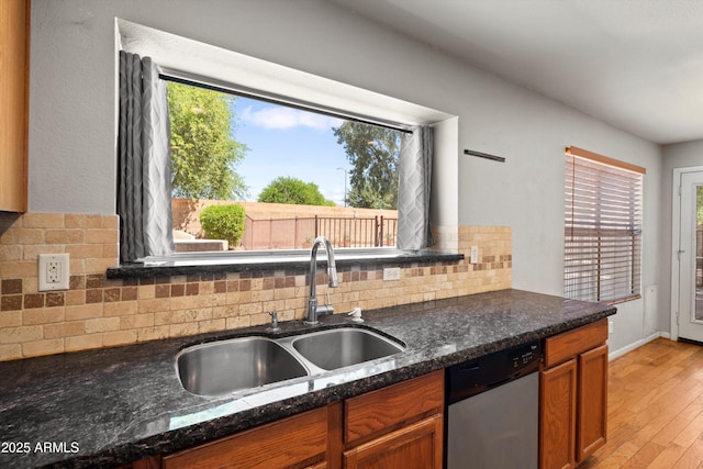 2024 N 125th Ave, Avondale, AZ 85392 - kitchen with dishwasher, decorative backsplash, light wood finished floors, dark stone countertops, and brown cabinetry