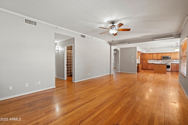 2024 N 125th Ave, Avondale, AZ 85392 - unfurnished living room featuring ceiling fan, light wood-style flooring, arched walkways, and crown molding