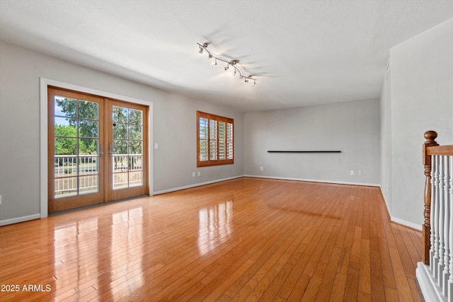 2024 N 125th Ave, Avondale, AZ 85392 - unfurnished room with light wood-type flooring, rail lighting, and french doors