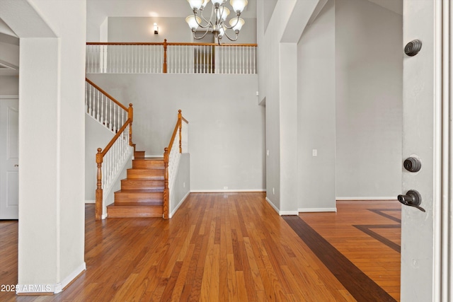 2024 N 125th Ave, Avondale, AZ 85392 - entryway with a chandelier, hardwood / wood-style flooring, a high ceiling, arched walkways, and stairway
