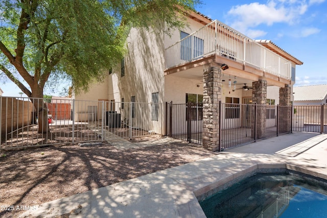 2024 N 125th Ave, Avondale, AZ 85392 - back of property featuring a balcony, a ceiling fan, a gate, stucco siding, and a jacuzzi