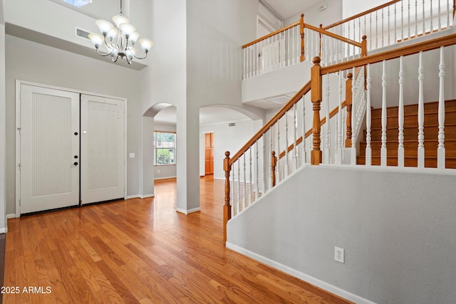 2024 N 125th Ave, Avondale, AZ 85392 - foyer with arched walkways, wood finished floors, a chandelier, a towering ceiling, and stairway