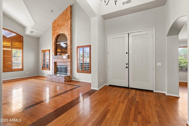 2024 N 125th Ave, Avondale, AZ 85392 - entrance foyer with high vaulted ceiling, arched walkways, wood-type flooring, and a brick fireplace