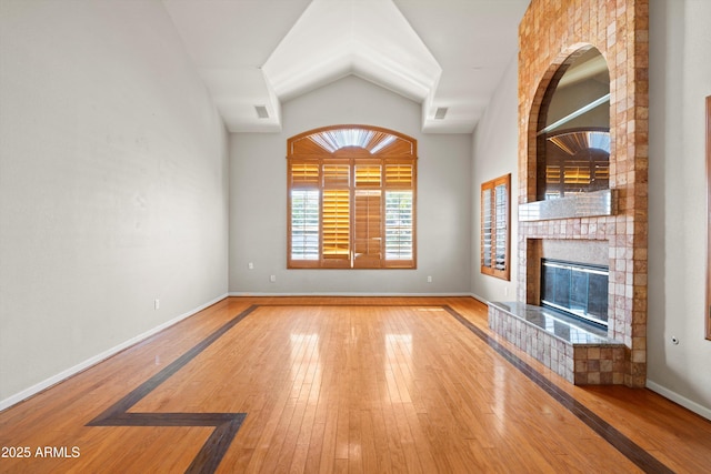 2024 N 125th Ave, Avondale, AZ 85392 - unfurnished living room featuring hardwood / wood-style flooring, a brick fireplace, and lofted ceiling
