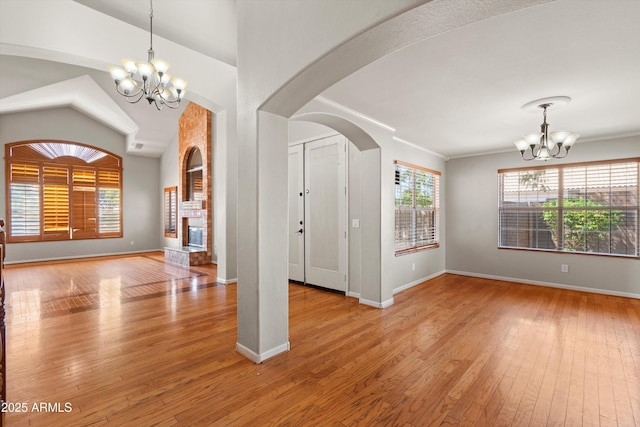 2024 N 125th Ave, Avondale, AZ 85392 - foyer entrance with a chandelier, hardwood / wood-style floors, a fireplace, arched walkways, and ornamental molding