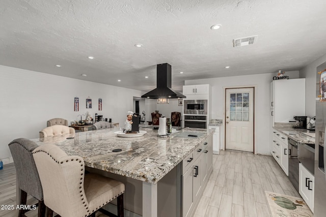 505 S S Rdg, Mesa, AZ 85204 - kitchen featuring island exhaust hood, stainless steel appliances, white cabinets, a breakfast bar, and recessed lighting