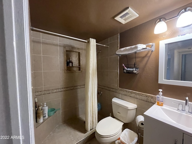 bathroom with walk in shower, tile walls, vanity, and toilet