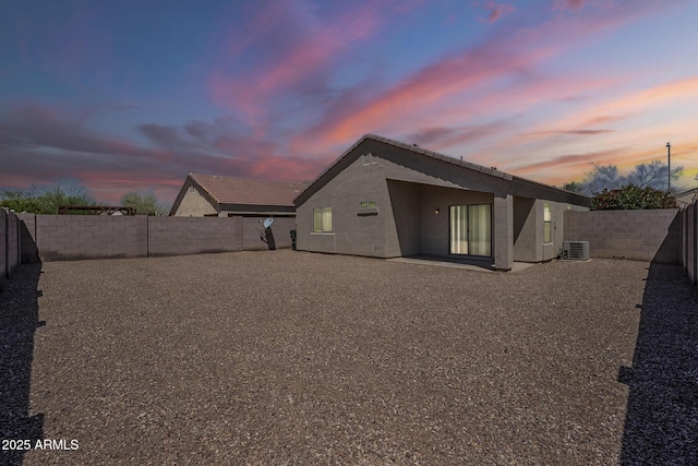 16077 W Larkspur Dr, Goodyear, AZ 85338 - back of house at dusk with central AC, stucco siding, a fenced backyard, a patio, and a tiled roof