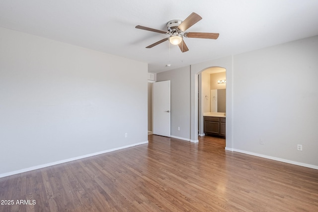 16077 W Larkspur Dr, Goodyear, AZ 85338 - unfurnished room with arched walkways, ceiling fan, light wood-type flooring, and baseboards