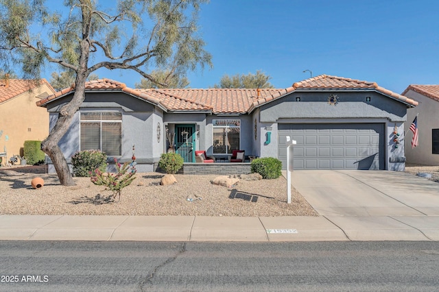 mediterranean / spanish-style house with driveway, a tile roof, a garage, and stucco siding