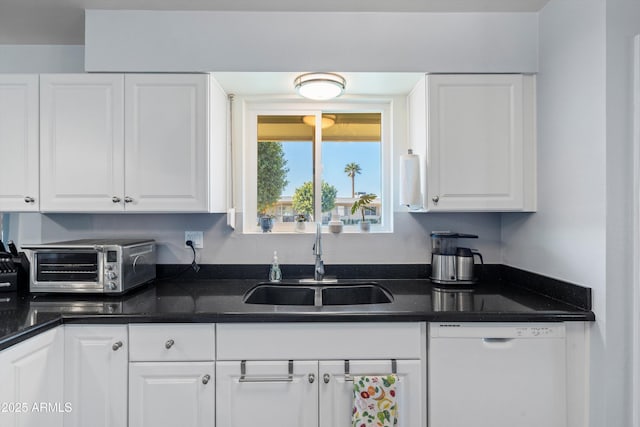 kitchen with white dishwasher, white cabinetry, and sink