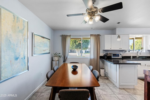 dining room with ceiling fan, light tile patterned floors, and sink