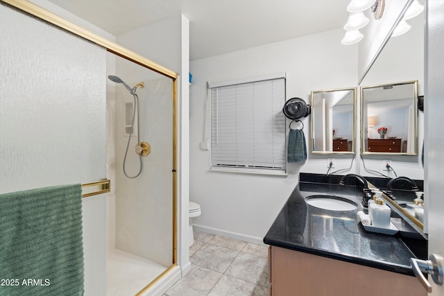 bathroom featuring toilet, vanity, tile patterned floors, and a shower with door